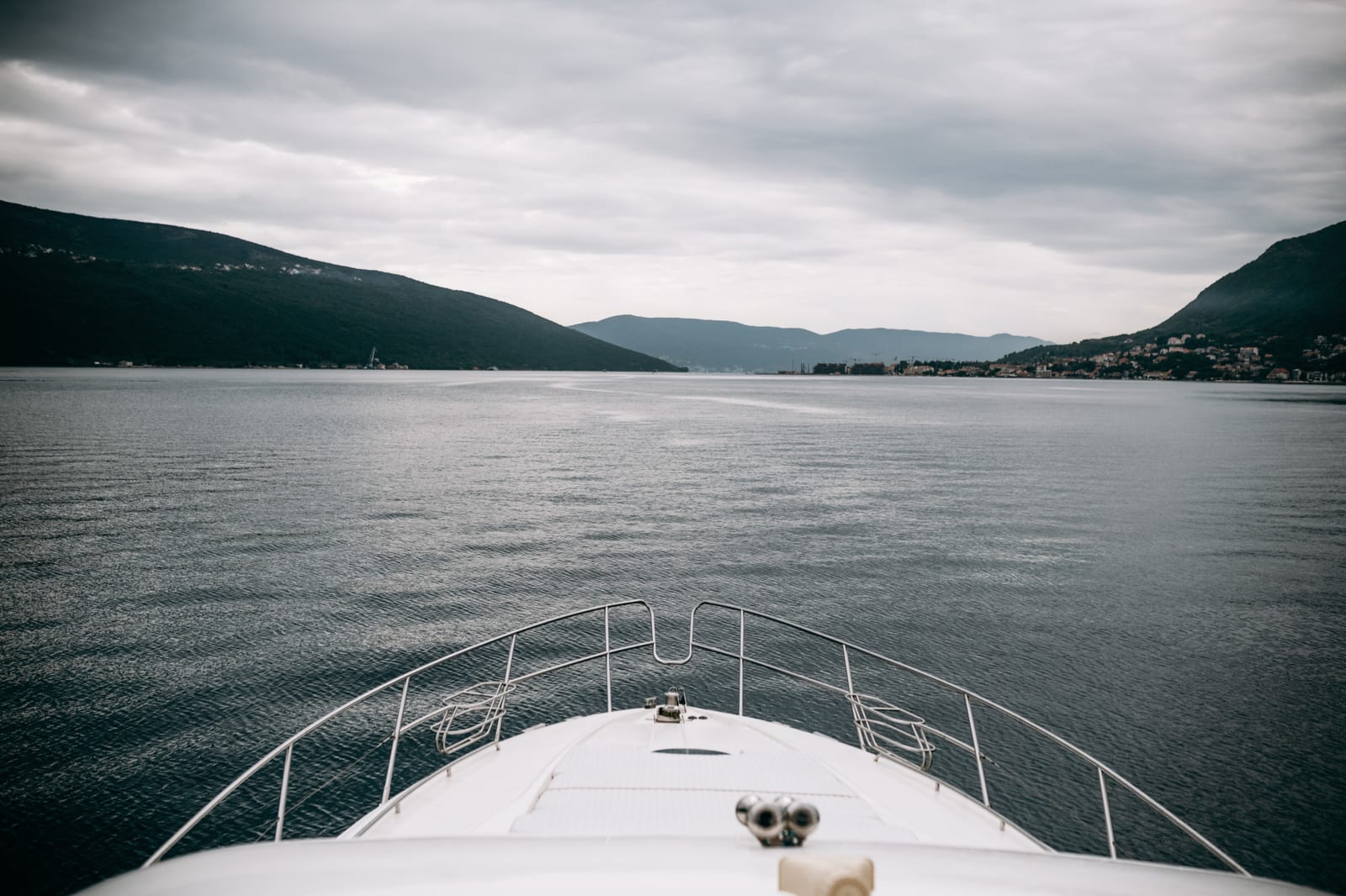 Yacht bianco che attraversa il mare con la costa sullo sfondo